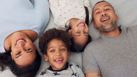 love, happy and face of family relaxing on a bed