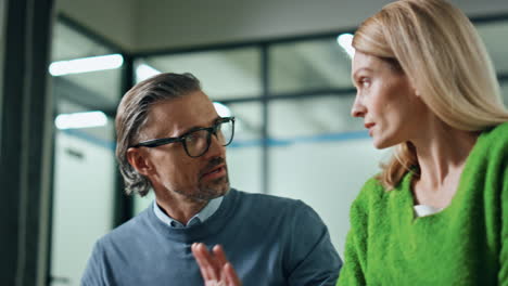 Two-partners-speaking-together-at-meeting-close-up.-Business-couple-discussing