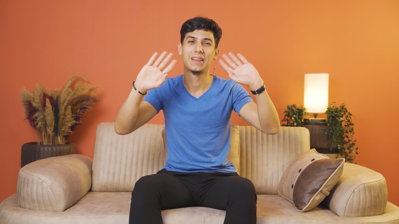 카메라를 향해 손을 흔드는 행복한 남자.