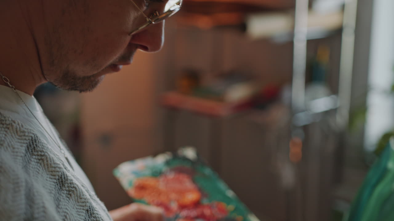 artista aplicando trazos en negrita en el lienzo con pincel en el estudio