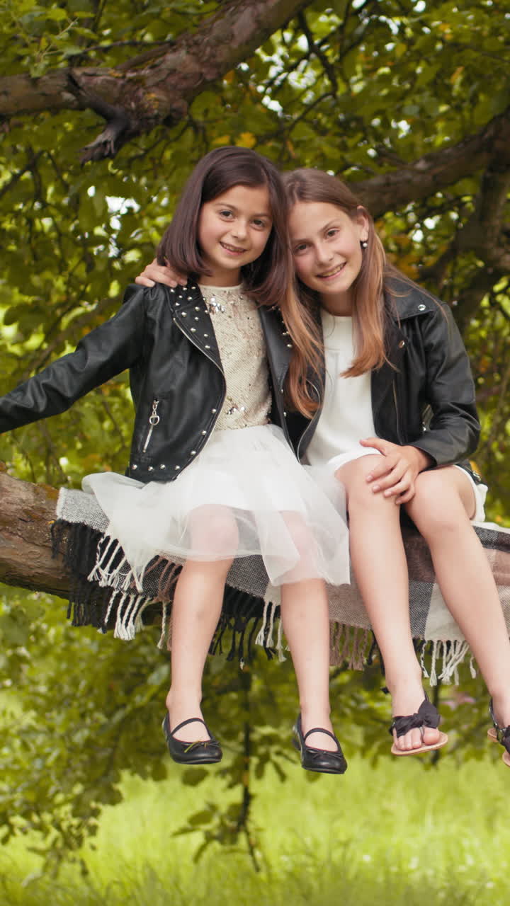 Girls on a tree branch vertical