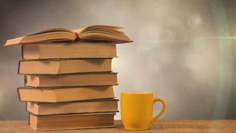 animation of stack of books with yellow mug over glowing lights