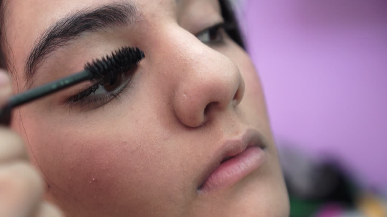 la chica usa rímel en sus cejas.