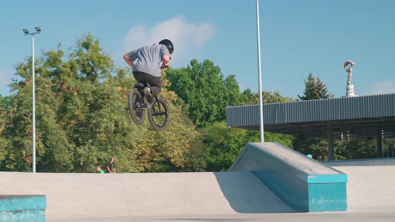 Giovane uomo in bici BMX che esegue un salto al rallentatore