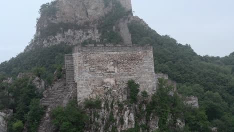 view of deteriorated square lookout tower of great wall of china, on a cloudy day