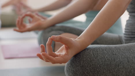 close up hands yoga women practicing lotus pose enjoying mindfulness meditation sitting on exercise mat in wellness studio