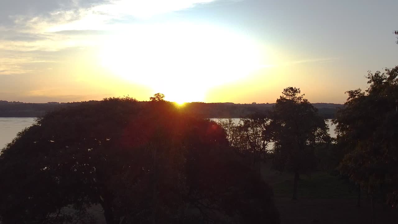 filmagens aéreas cinematográficas do pôr-do-sol atrás das árvores em misiones, jardin, américa, argentina, drone