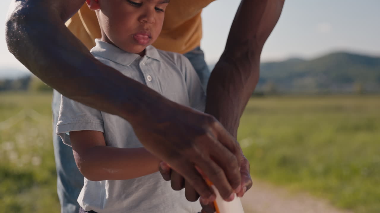 Father taking care of the childs skin protection and sun safety applying sunscreen lotion to his