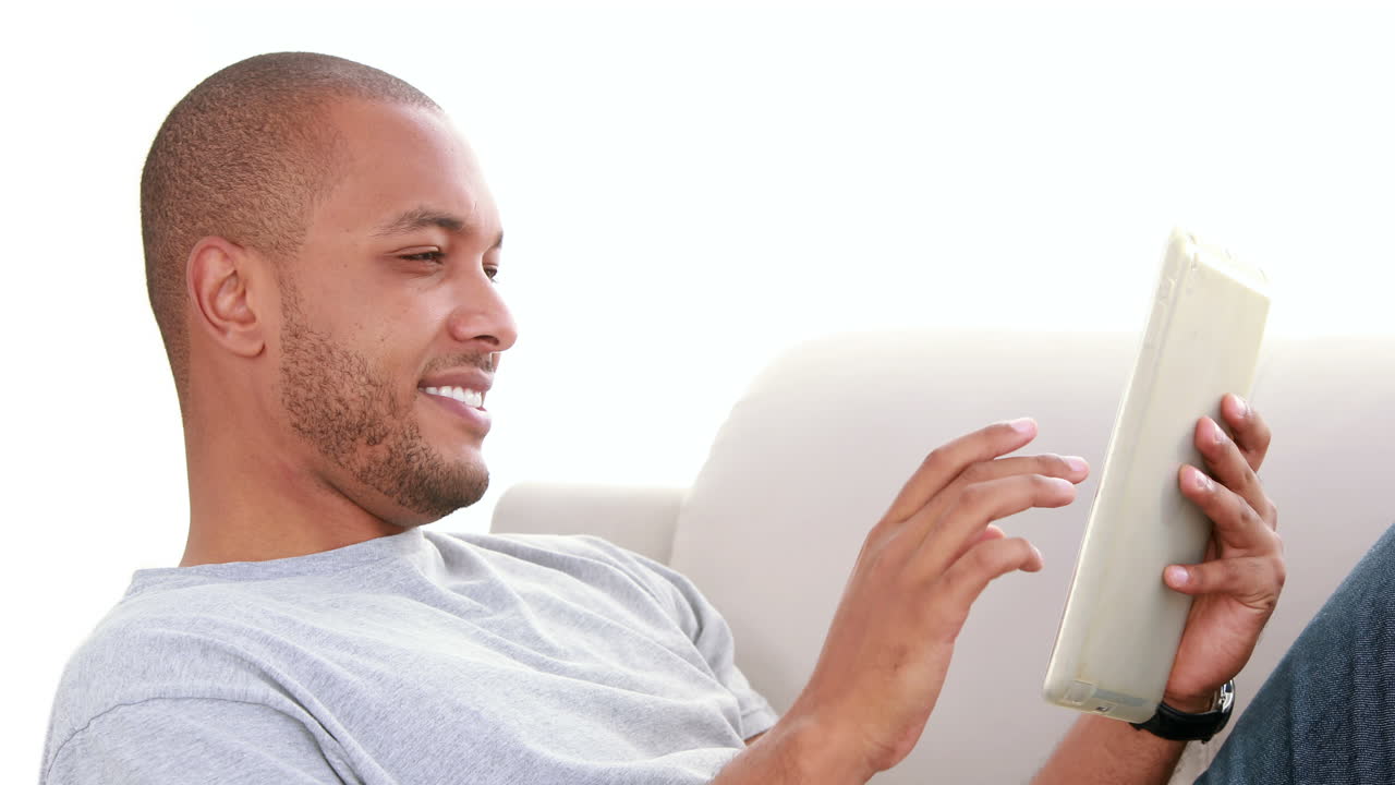 Relaxed man scrolling on the tablet