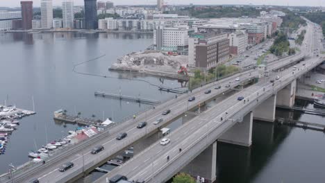 traffic going over canal on bridge in södermalm, stockholm, sweden during cloudy evening