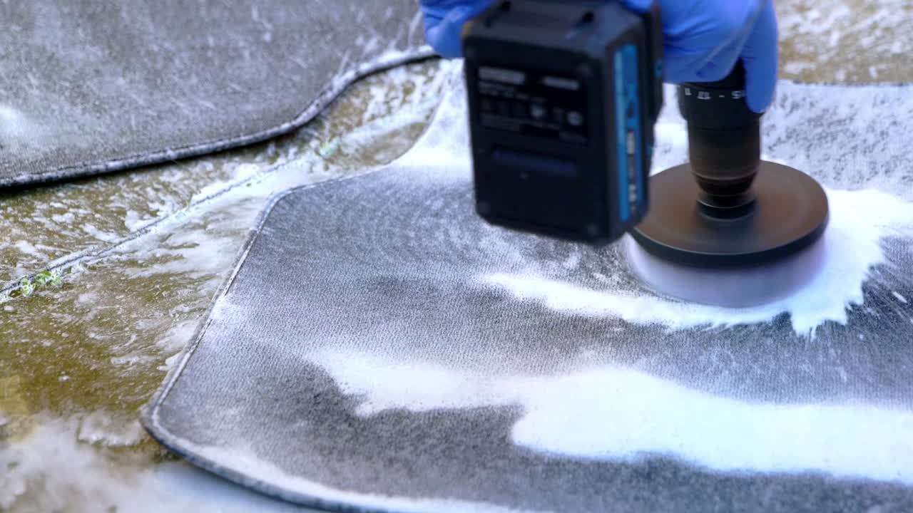 Cleaning a small car foot with a drill and brush attachment - extreme close up - tight shot