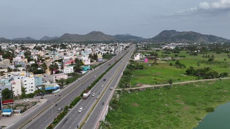 Aerial-shot-of-the-scenic-route-with-the-highway-cutting-through-lush-greenery-and-small-hills