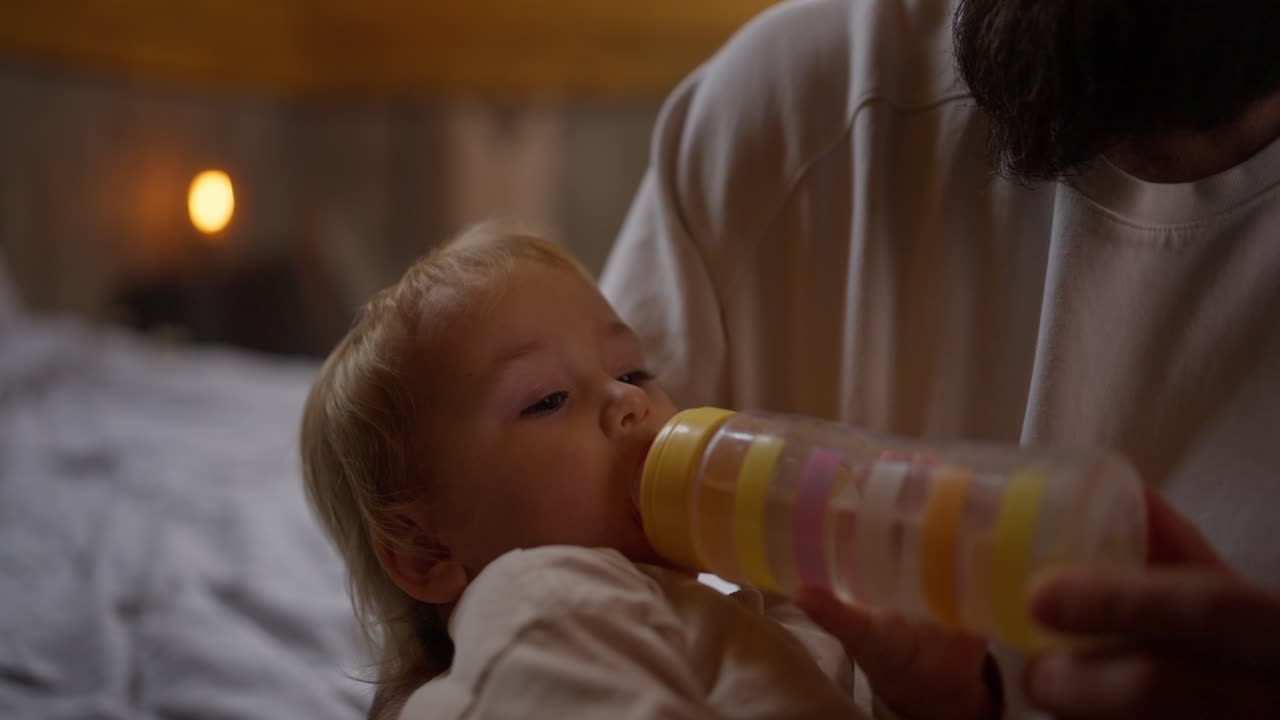 padre alimentando al bebé con el biberón