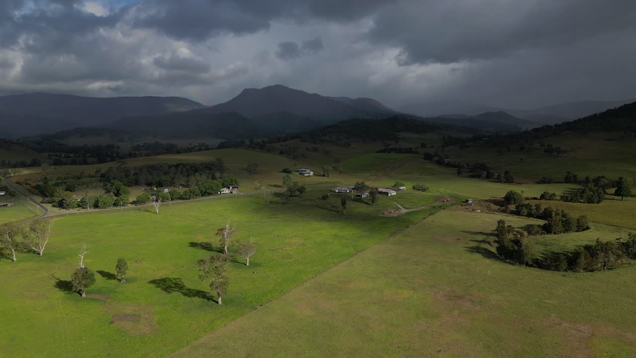 Luftfotos over landbrugsjord i Lamington i Scenic Rim med regn i det fjerne, Queensland, Australien
