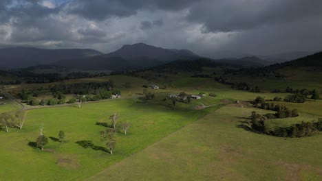 aerial views over farmland in lamington in the scenic rim with rain fall in the distance, queensland, australia