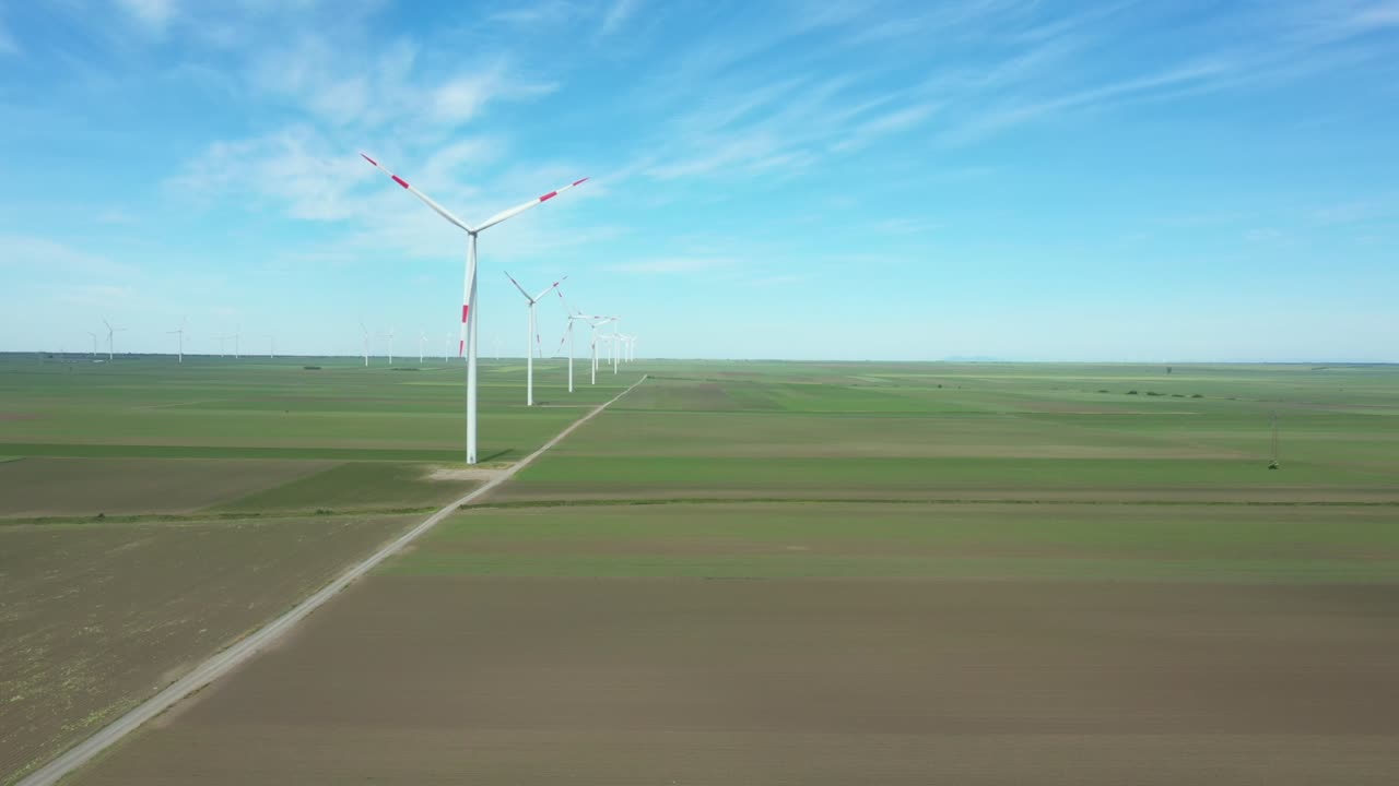 View of several windmills, wind generators, turbines, producing renewable clean energy by converting kinetic energy