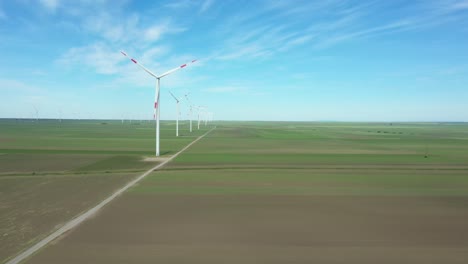 view of several windmills, wind generators, turbines, producing renewable clean energy by converting kinetic energy