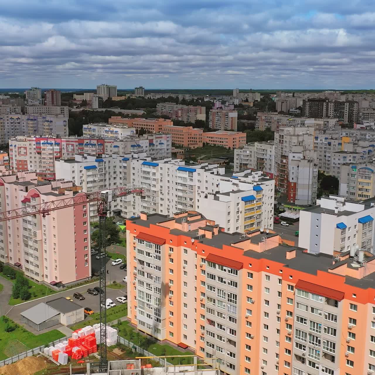 New architecture in the city. Luxury design of apartment building in a sunny day. Orange and white high-rise apartment with balconies. View from the drone