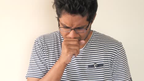 hombre tosendo y sosteniendo la cabeza, sintiéndose enfermo