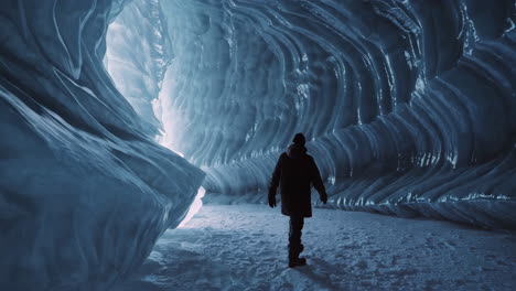 a person walking through a stunning blue ice cave