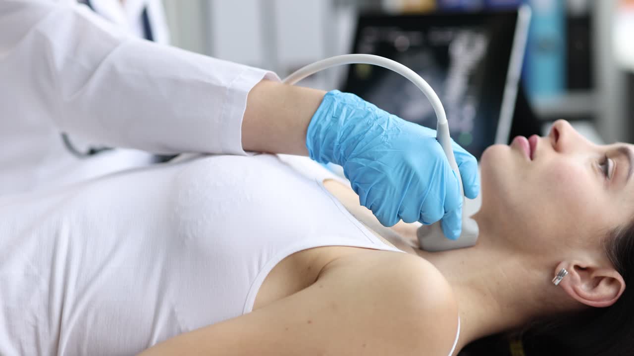 La dottoressa esegue un'ecografia al collo del paziente per controllare la tiroide.