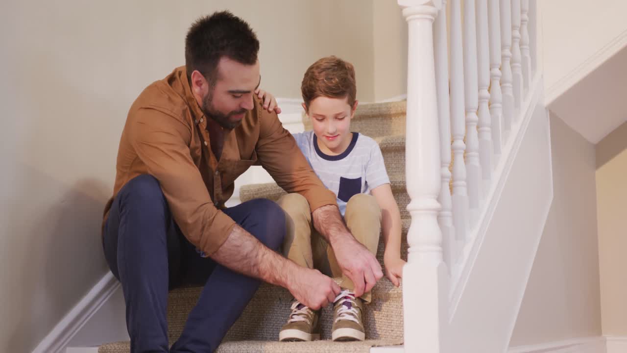 hombre caucásico y su hijo sentados en las escaleras