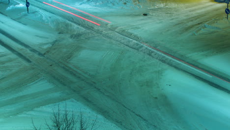 time lapse of traffic on an intersection covered with snow at winter night