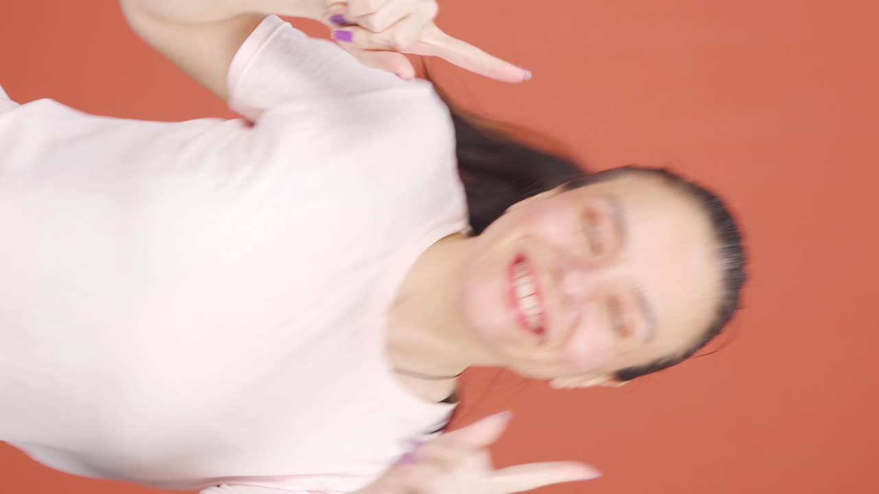 그 여자가 재미있게 춤을 추는 수직 비디오입니다.