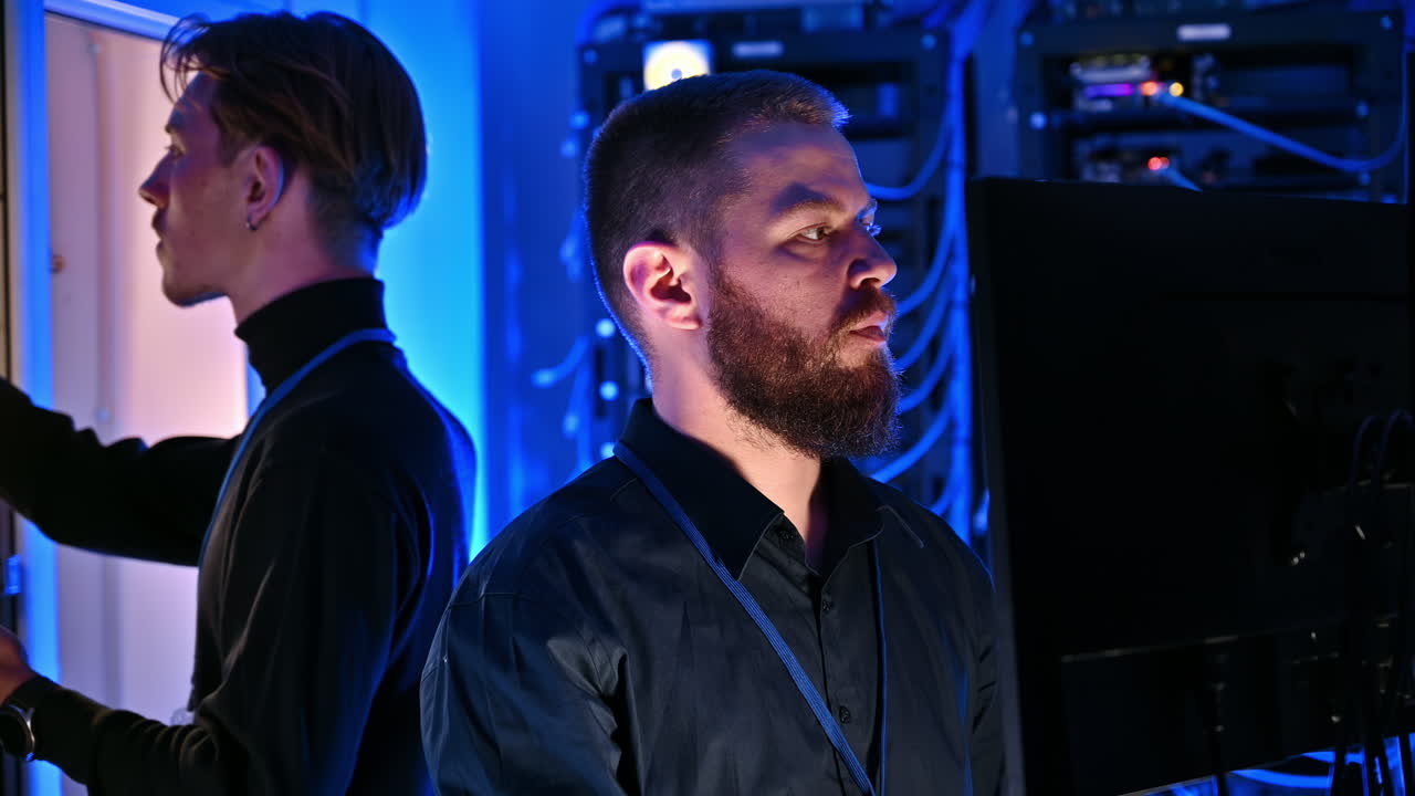 Two men managing data in a server room