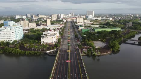 forward drone footage overlooking an urban city filled with trees in the philippines called iloilo on a cloudy morning