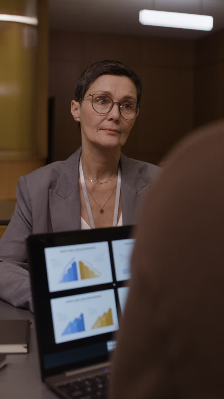 Businesswoman reviewing charts and graphs on a laptop