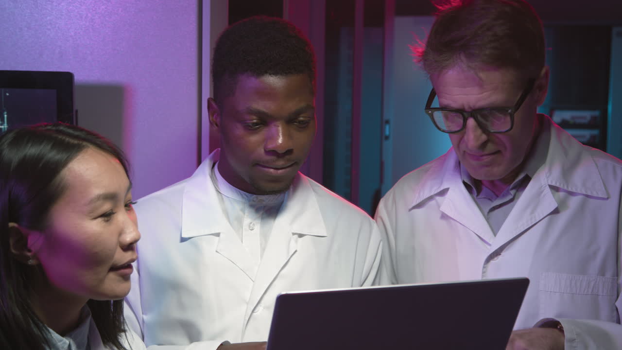 Network Engineers in Lab Coats Working in Data Center