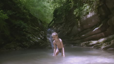 boy playing in a mountain stream