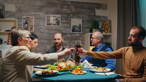 Young-man-and-his-mother-clinking-a-glass-of-red-wine