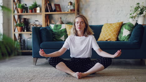 woman meditating in a living room