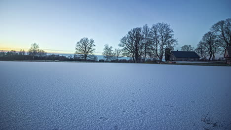 sunset over a winter landscape with a large snow-covered meadow