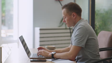 happy business man working on laptop from home office. male executive using computer remote studying browsing web having virtual meeting typing on computer. remote office