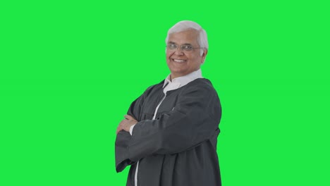 retrato de un abogado senior indio feliz de pie con las manos cruzadas pantalla verde