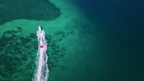 aerial view of motorboat pulling inflatable boat on the caribbean sea in bocas del toro province, panama.