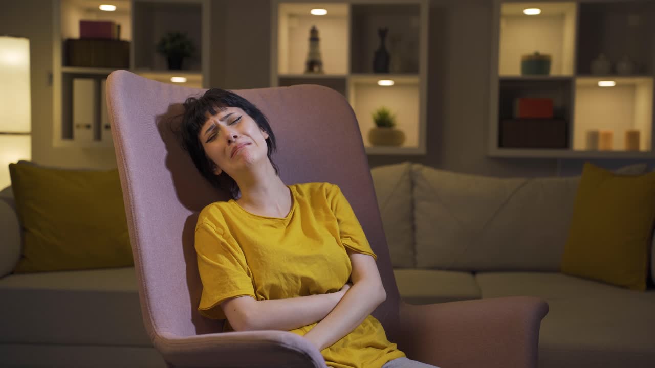 la joven acostada en el sofá está llorando.