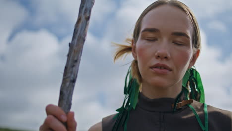 closeup traveler posing sky holding stick. confident serious woman look camera