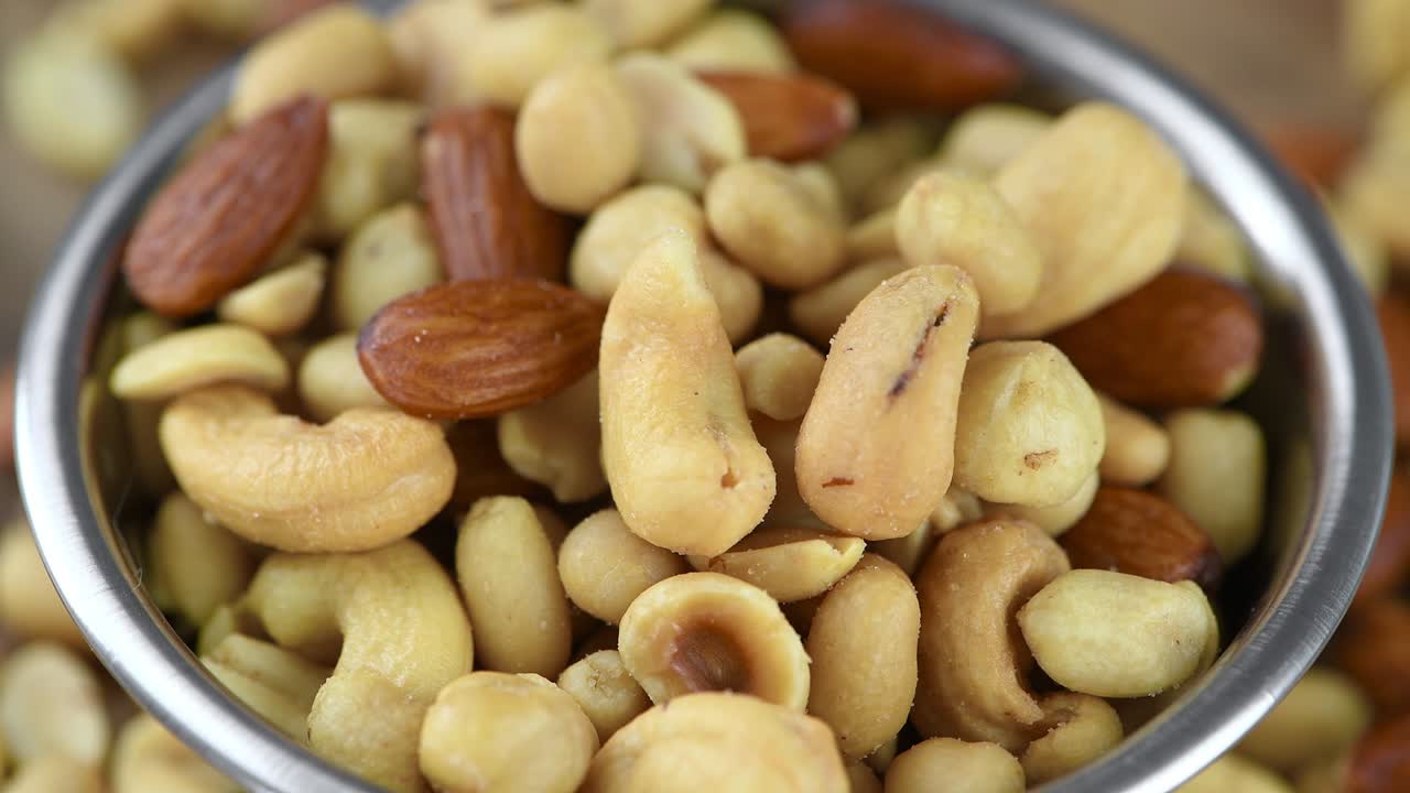 Frutta secca appena tostata su un piatto rotante (loop continuo)