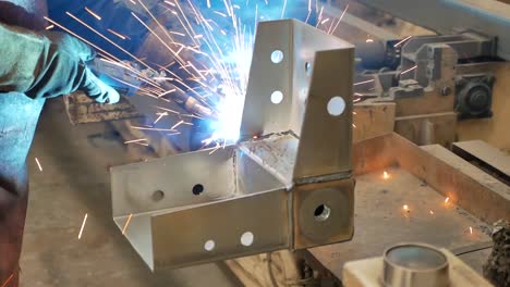 worker welding metal structure in factory
