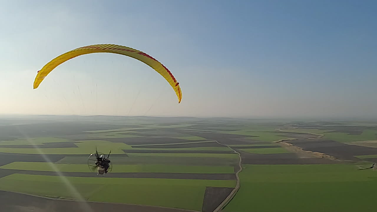 la antena sigue el paramotor en el cielo azul, la hélice gira debajo del dosel
