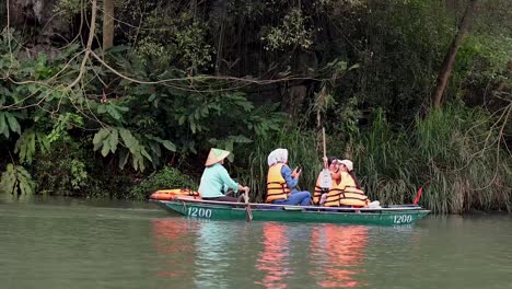 los turistas disfrutan de un paseo en barco en ninh binh