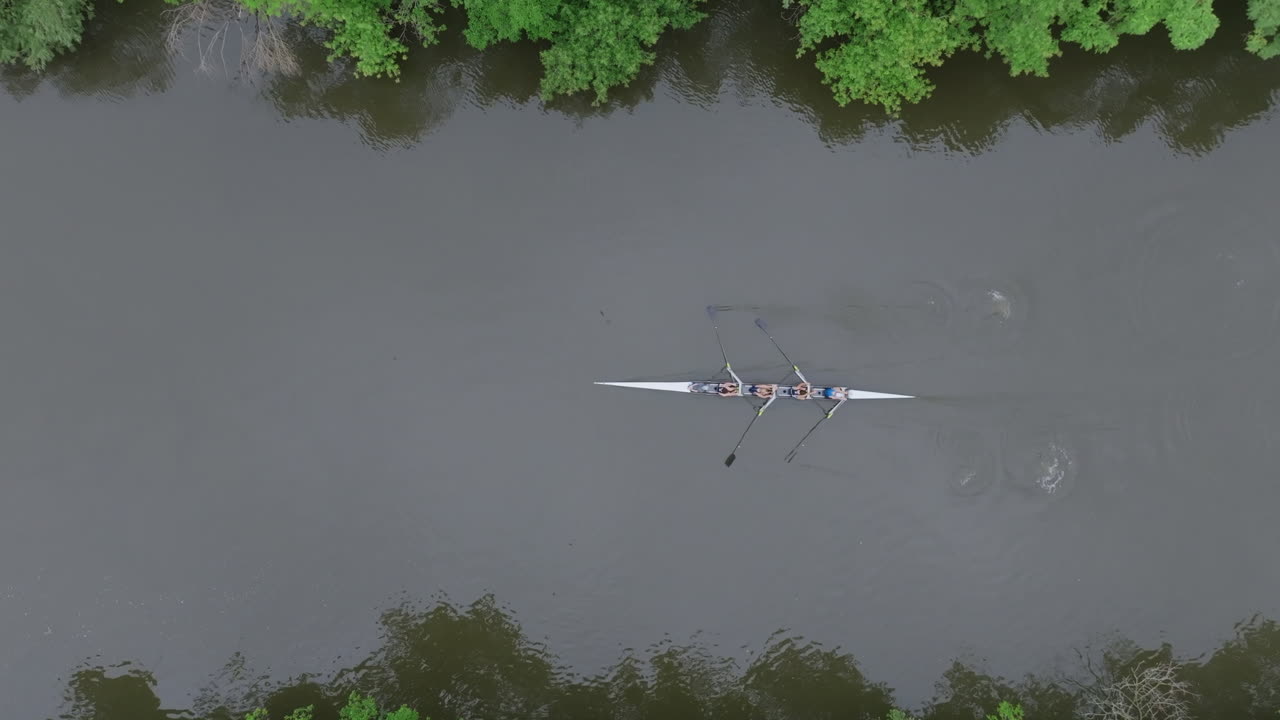 Luftfoto af et rohold på en flod fulgt af en motorbåd.