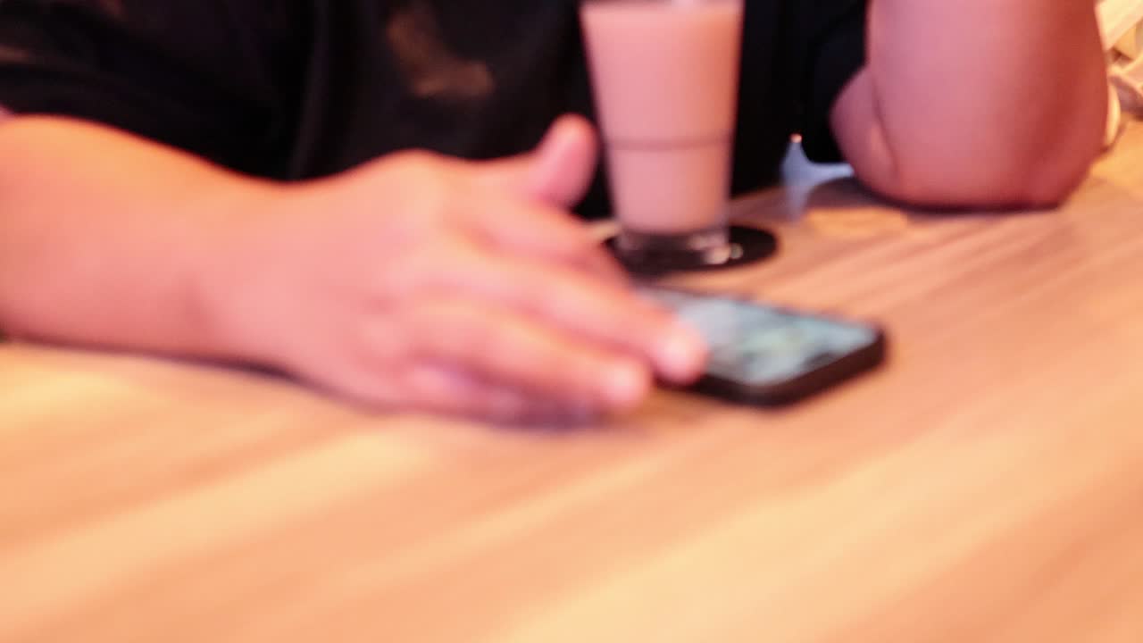 Person using phone at a cafe table