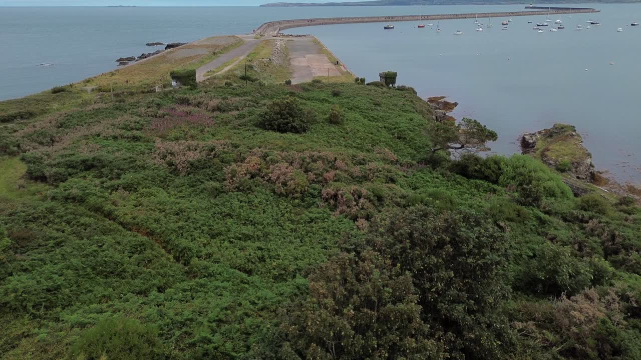 Neglected Soldiers point house remains aerial view flying towards Holyhead coastal breakwater