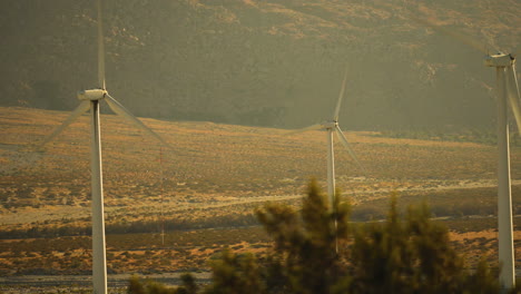 Steady-close-up-shot-of-3-rotors-and-blades-of-wind-turbines-at-a-wind-farm-near-Palm-Springs-in-the-Mojave-Desert,-California,-USA