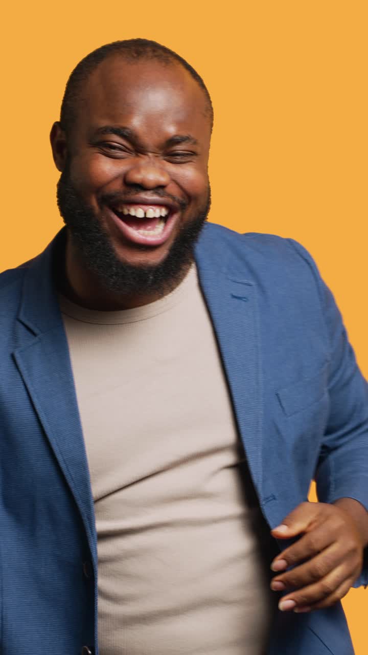 Vídeo vertical de um homem alegre celebrando, com fundo de estúdio